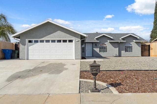 ranch-style house featuring concrete driveway, an attached garage, fence, and stucco siding