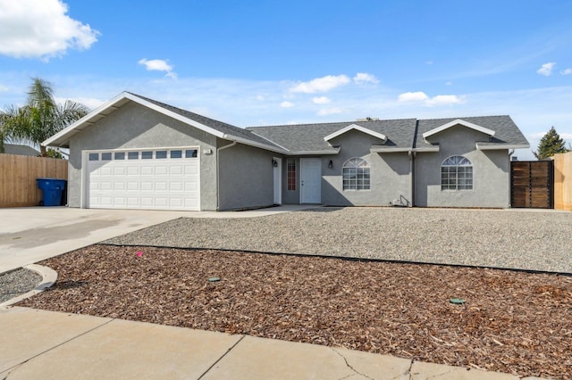 ranch-style home featuring an attached garage, driveway, fence, and stucco siding