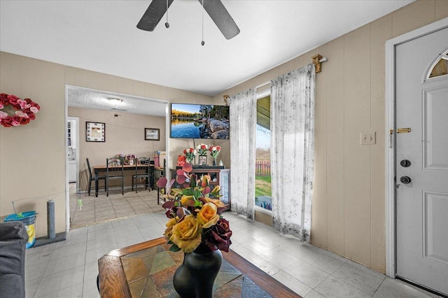 interior space with a ceiling fan and light tile patterned flooring