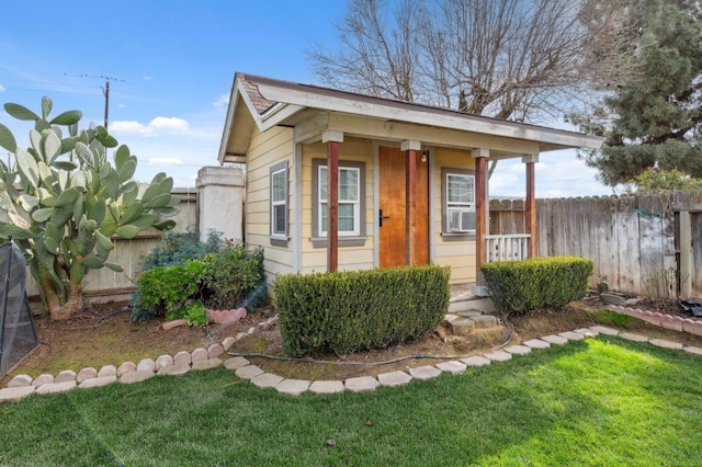 exterior space with a lawn, an outdoor structure, and fence