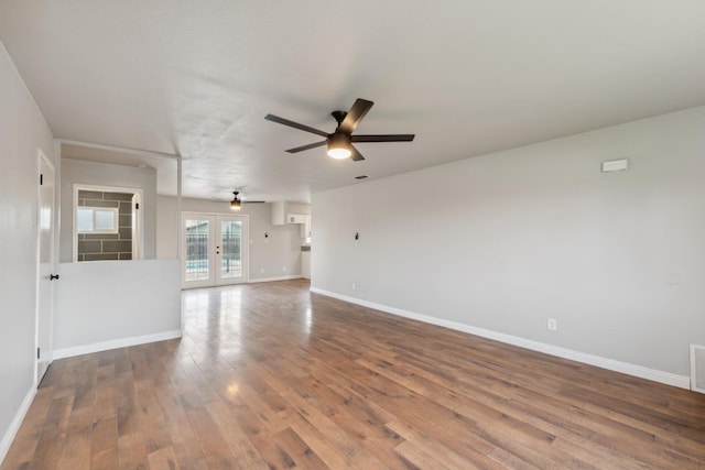 unfurnished living room with visible vents, baseboards, a ceiling fan, wood finished floors, and french doors