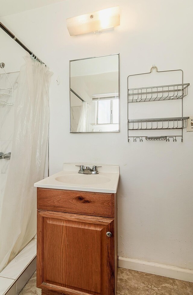 bathroom with a shower with shower curtain, vanity, and baseboards