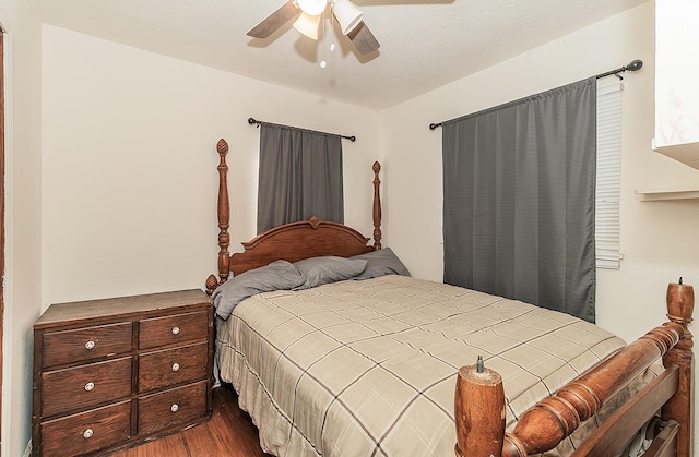 bedroom featuring a ceiling fan and dark wood-style flooring