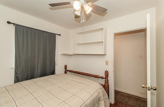 bedroom with a ceiling fan, a textured ceiling, and wood finished floors