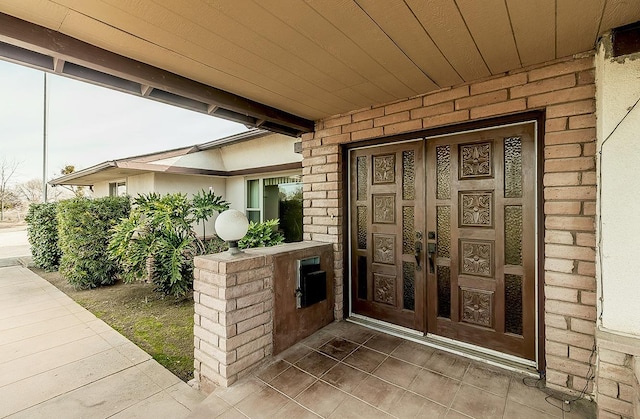 property entrance featuring french doors and brick siding