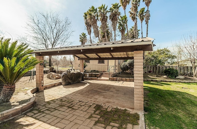 view of patio with a carport and fence