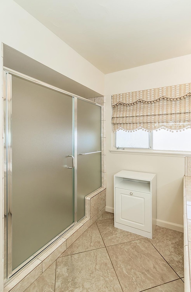 full bath with baseboards and a shower with shower door