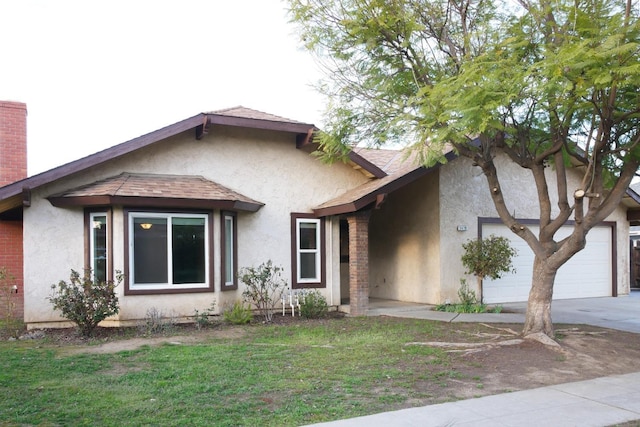 view of front facade featuring a garage, driveway, roof with shingles, and stucco siding