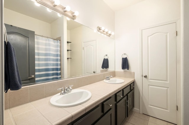 bathroom with double vanity, tile patterned flooring, and a sink