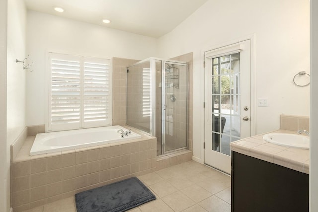 bathroom featuring a garden tub, a shower stall, vanity, and tile patterned floors