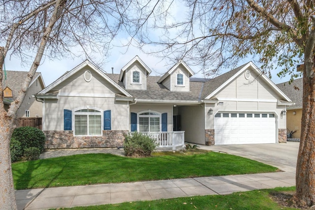 view of front facade featuring a front lawn, stone siding, an attached garage, and concrete driveway