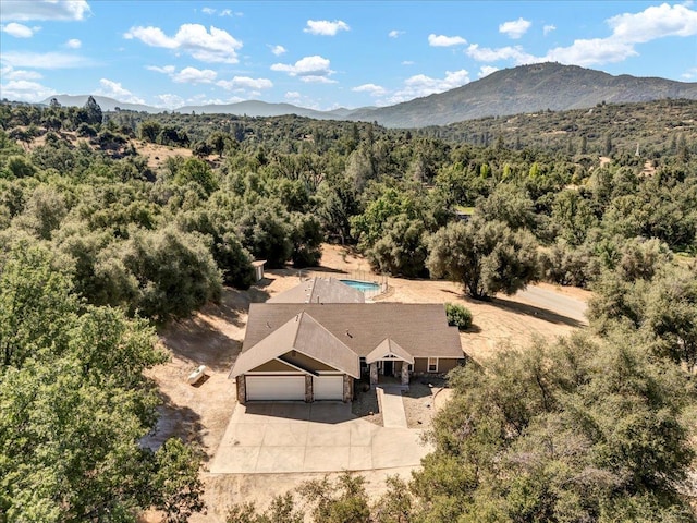 birds eye view of property featuring a forest view and a mountain view