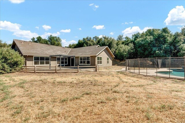 back of house with a patio, a lawn, fence, and a fenced in pool