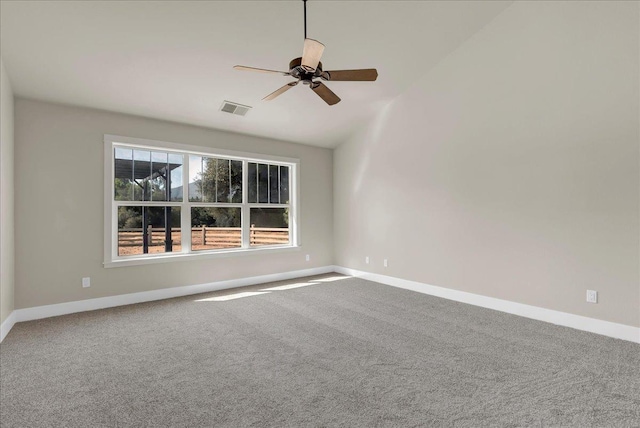 carpeted spare room featuring lofted ceiling, ceiling fan, visible vents, and baseboards