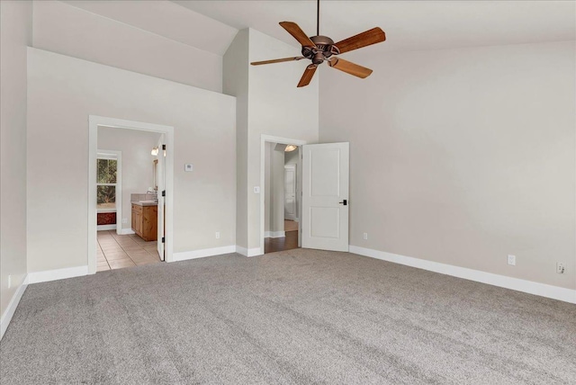 unfurnished bedroom featuring light tile patterned floors, high vaulted ceiling, ensuite bathroom, light carpet, and baseboards