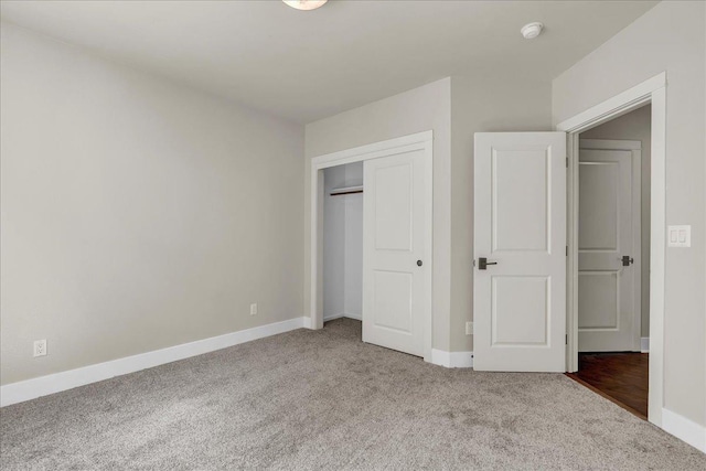 unfurnished bedroom featuring a closet, carpet flooring, and baseboards