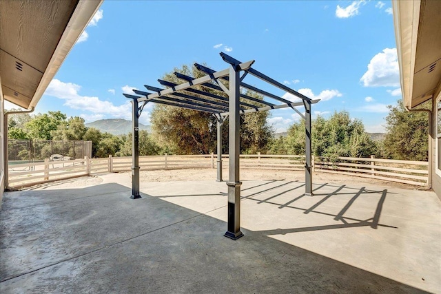 view of patio featuring a fenced backyard, a mountain view, and a pergola