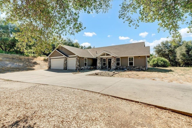 single story home with stone siding, concrete driveway, and an attached garage