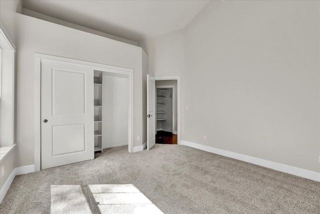 unfurnished bedroom featuring carpet floors, baseboards, and a closet