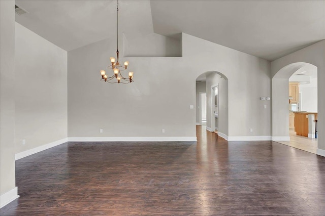 unfurnished room featuring dark wood-type flooring, arched walkways, visible vents, and baseboards