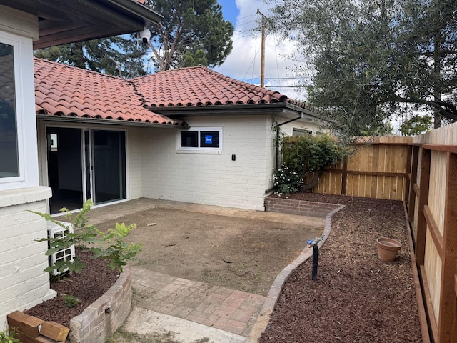 506 W Terrace Ave, Fresno, CA 93705 - back of property with fence, a patio area, brick siding, and a tiled roof