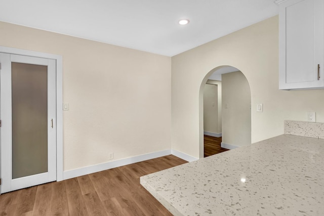 506 W Terrace Ave, Fresno, CA 93705 - kitchen with white cabinetry, wood finished floors, baseboards, arched walkways, and recessed lighting