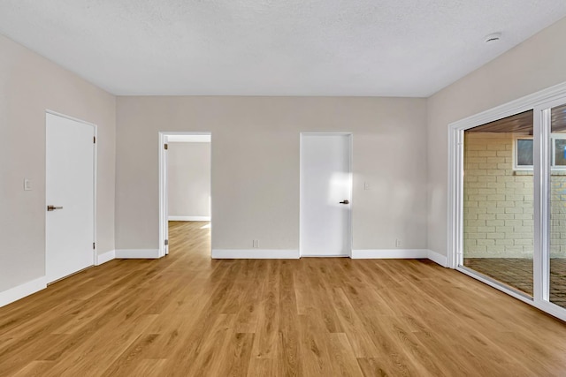 506 W Terrace Ave, Fresno, CA 93705 - unfurnished bedroom featuring light wood finished floors, baseboards, and access to exterior