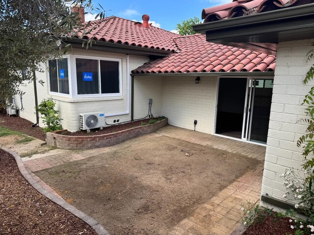 506 W Terrace Ave, Fresno, CA 93705 - rear view of property featuring a tiled roof, ac unit, a patio area, and brick siding