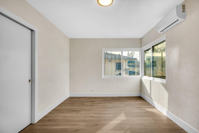 506 W Terrace Ave, Fresno, CA 93705 - empty room featuring a wall mounted air conditioner, baseboards, and wood finished floors