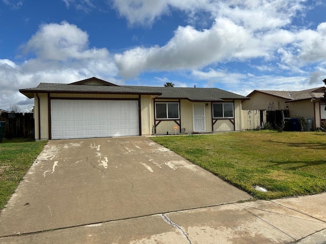 ranch-style house with a garage, concrete driveway, fence, and a front lawn