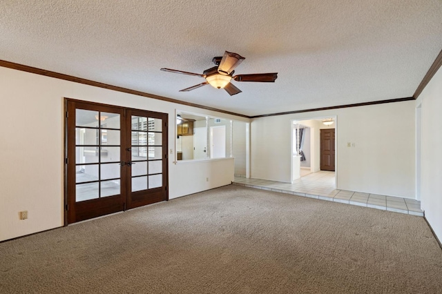 empty room featuring light carpet, french doors, a textured ceiling, and ornamental molding