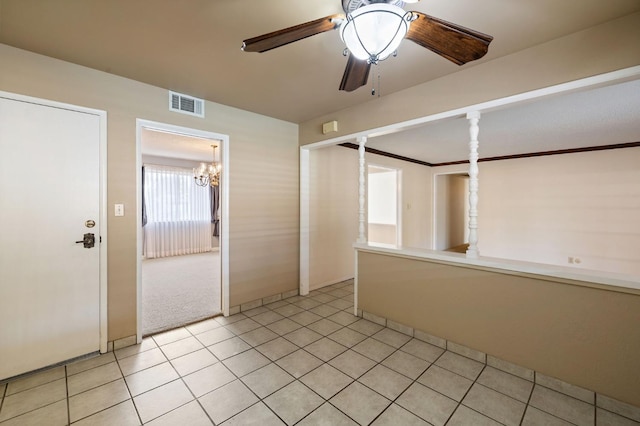 unfurnished room with light tile patterned floors, crown molding, visible vents, and a ceiling fan