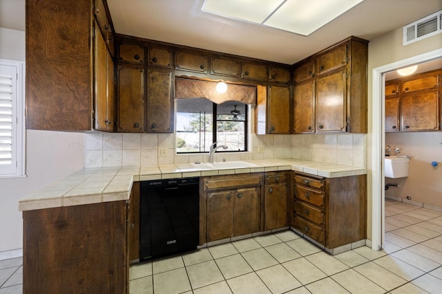 kitchen with black dishwasher, tile countertops, tasteful backsplash, visible vents, and dark brown cabinetry