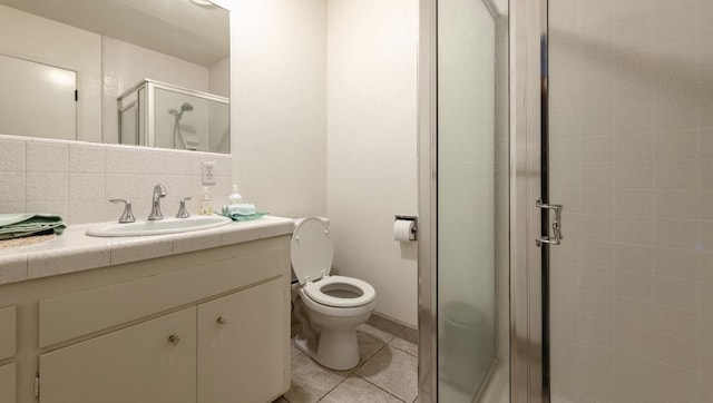 full bath with toilet, vanity, a shower stall, tile patterned floors, and tasteful backsplash