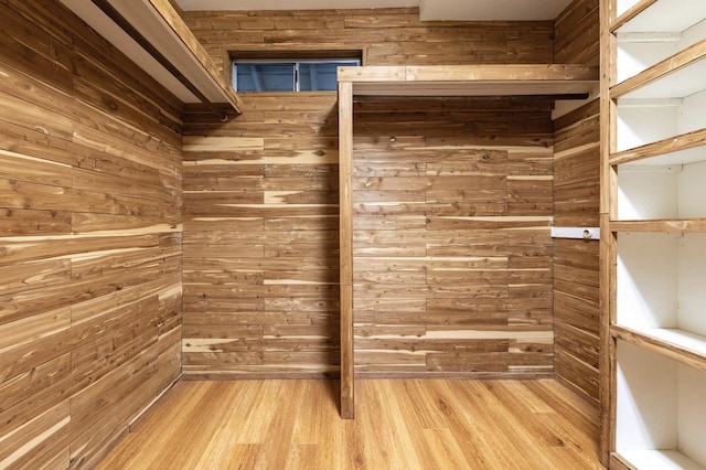 walk in closet with light wood-style floors