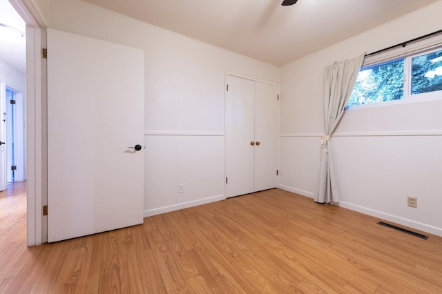 spare room with baseboards, visible vents, ceiling fan, and light wood finished floors