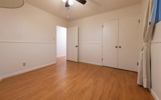 unfurnished bedroom with light wood-style floors, a closet, baseboards, and a ceiling fan