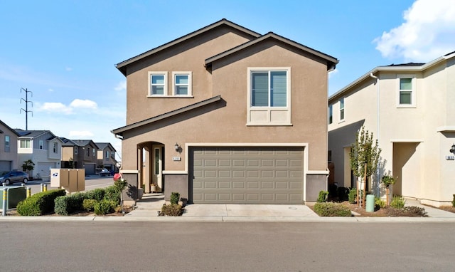 view of front of property featuring driveway, a residential view, and stucco siding