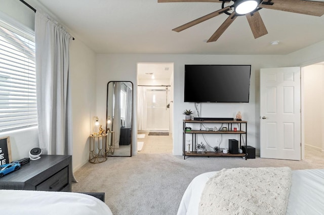 bedroom with ceiling fan, connected bathroom, and light colored carpet