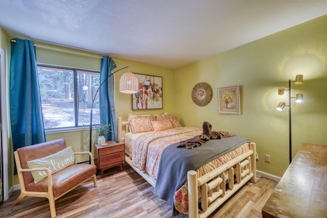bedroom featuring wood finished floors and baseboards