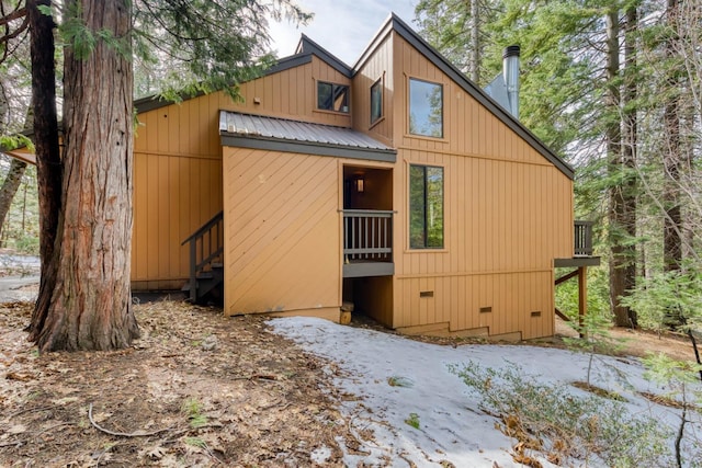 back of house with metal roof and crawl space