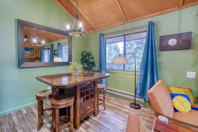 dining space with wood finished floors, a chandelier, a wealth of natural light, vaulted ceiling, and baseboards