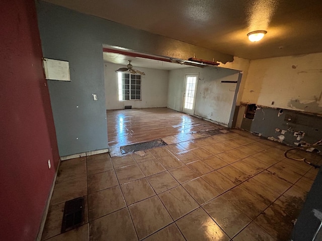 interior space with a textured ceiling, tile patterned flooring, and visible vents