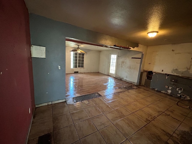 tiled spare room featuring a textured ceiling