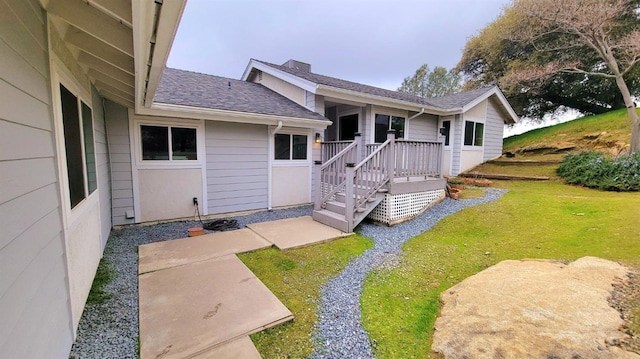 exterior space with a front yard and a shingled roof