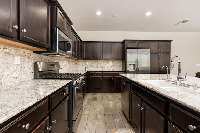 3384 Amanecer Ave, Clovis, CA 93619 - kitchen featuring stainless steel appliances, a sink, light stone counters, dark brown cabinets, and recessed lighting