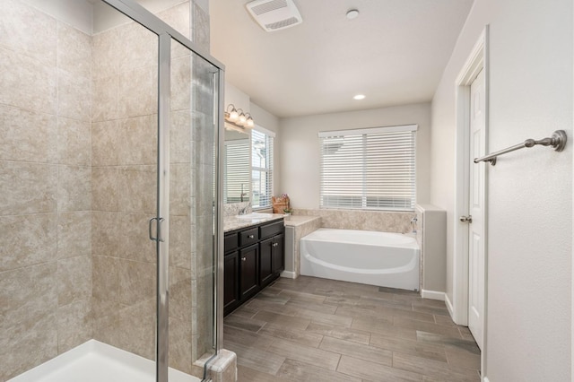 3384 Amanecer Ave, Clovis, CA 93619 - bathroom featuring a stall shower, vanity, a bath, wood finished floors, and recessed lighting