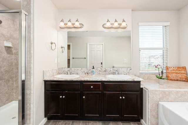 full bath with a garden tub, double vanity, a sink, and a shower stall