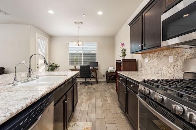 3384 Amanecer Ave, Clovis, CA 93619 - kitchen with stainless steel appliances, a sink, decorative backsplash, light wood finished floors, and recessed lighting