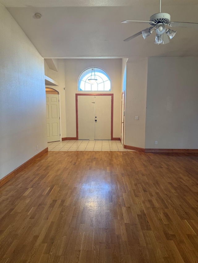 foyer featuring wood finished floors, a ceiling fan, and baseboards